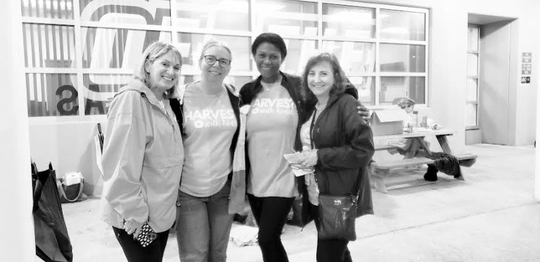 Black-and-white photo of Cypress Bay High School volunteers posing together outside the school