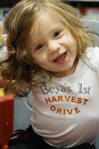 Smiling toddler wearing a shirt celebrating a first Harvest Drive