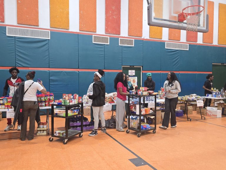 Blanche Ely High School students working around tables and carts of food in the school gym