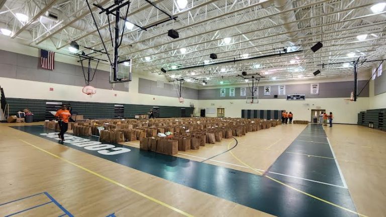 Glades Middle School gym filled with rows of packed brown paper grocery bags