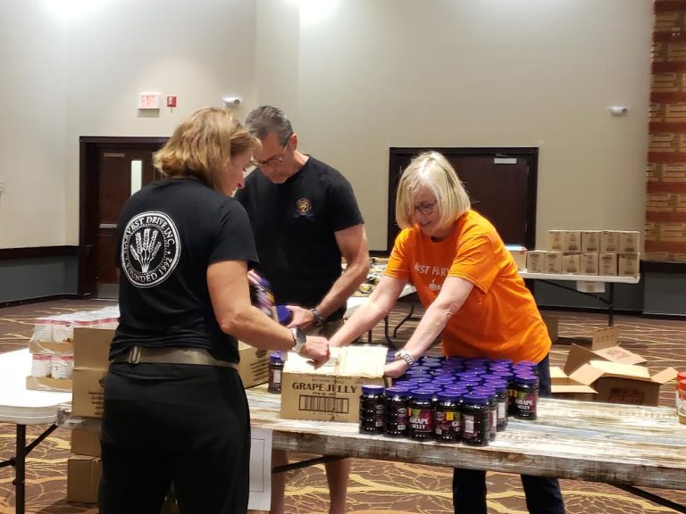 Volunteers packing jars of grape jelly into boxes at JCares Mitzvah Day
