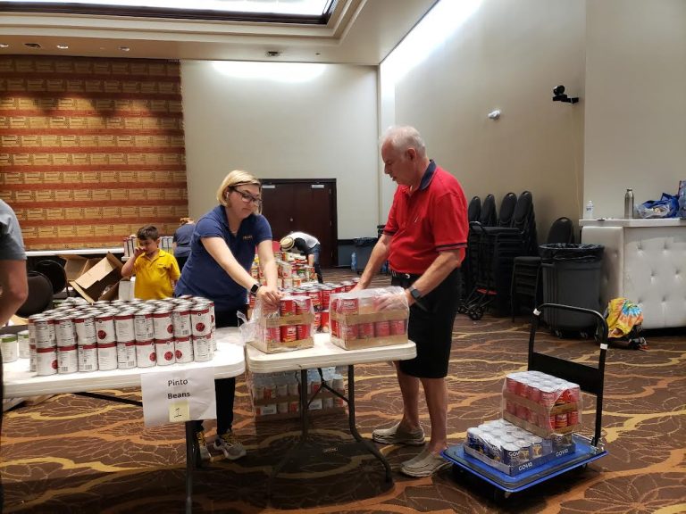 Volunteers moving canned goods from tables into boxes at JCares Mitzvah Day