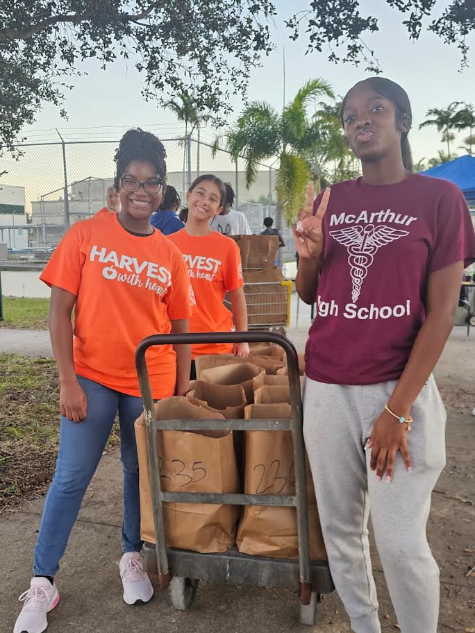 McArthur High School students with a cart of paper grocery bags outside the school