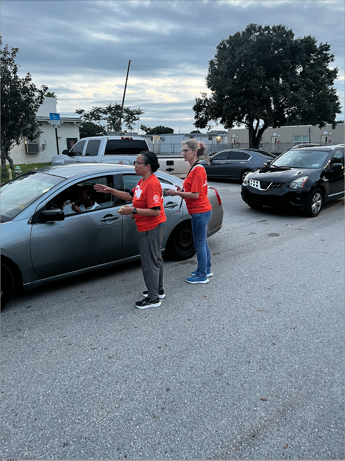 McArthur High School volunteers greeting a driver in the food pickup line
