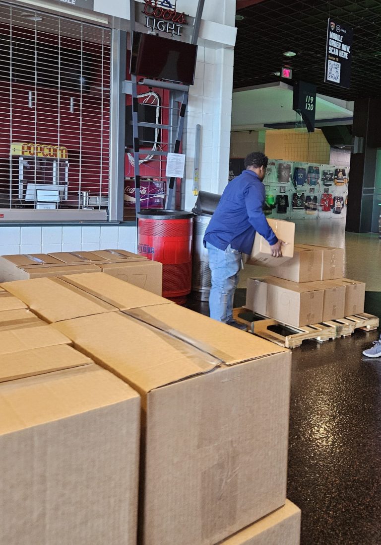 Volunteer stacking sealed boxes on pallets for Florida Panthers Box Packing