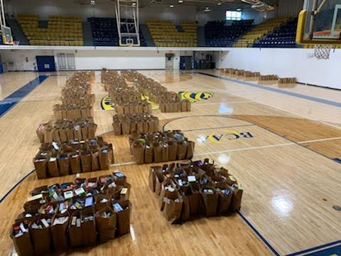 Pompano Beach High School gym floor lined with clusters of filled paper grocery bags
