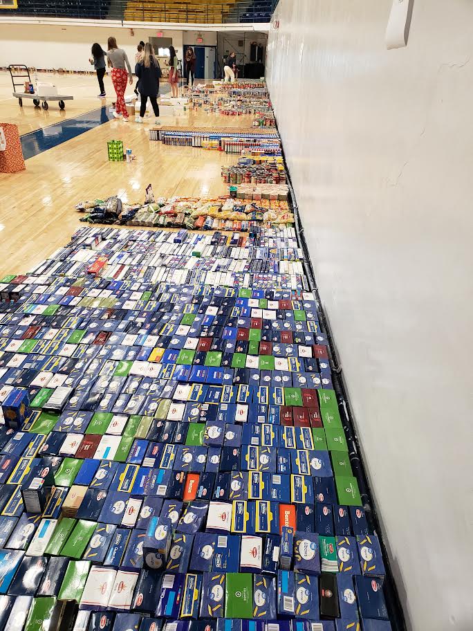Pompano Beach High School gym floor covered with long rows of boxed food