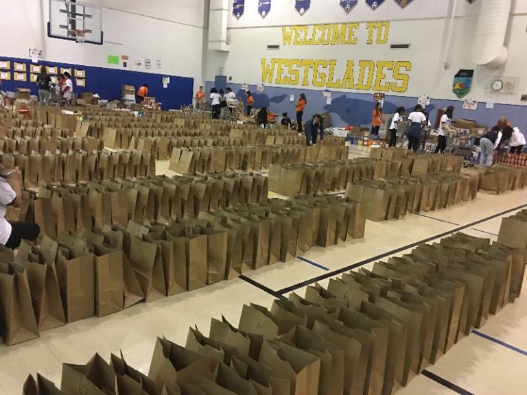 Hundreds of brown paper bags lined up in rows across the Westglades Middle School gym